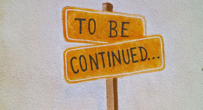 A yellow sign with black text on it saying 'to be continued'